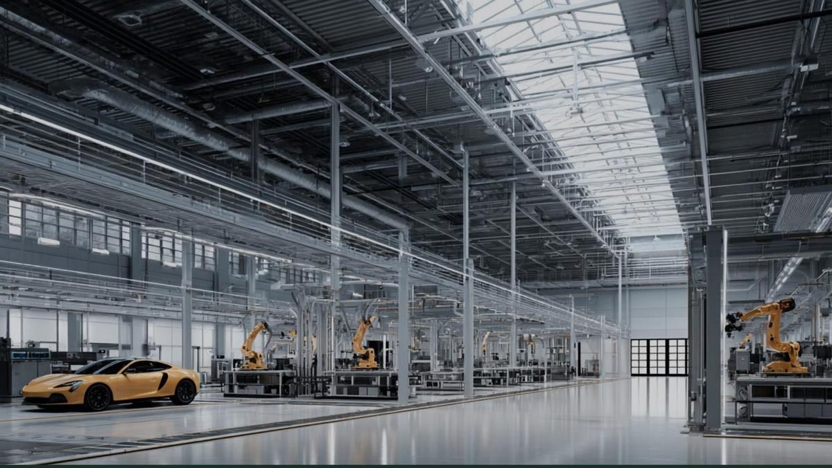 Automated electric vehicle assembly line with robotic arms inside a manufacturing hall